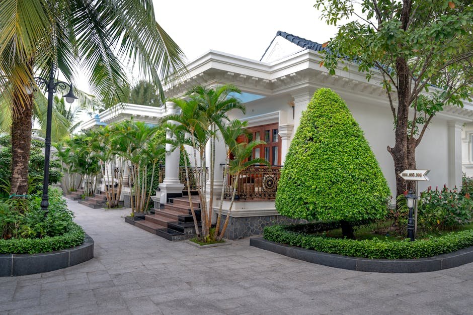 Elegant resort entrance surrounded by lush tropical greenery and manicured gardens.