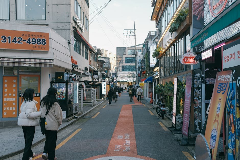 A bustling street scene in Seoul, South Korea, showcasing shops, pedestrians, and urban life.