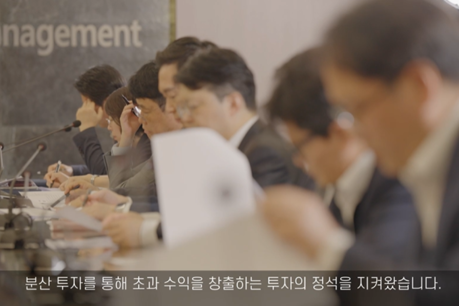 국민연금홍보영상-회의실에서 서류를 보고 있는 사람들을 측면에서 보고 있는 장면