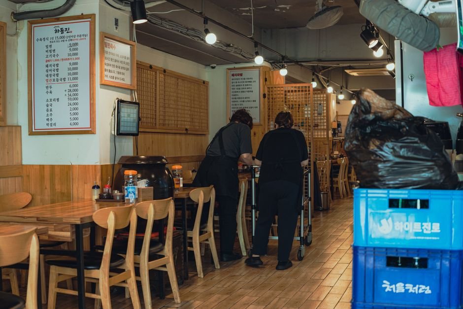 가맹점주가 몰랐다가 대출 못 받는다, 본부 연계 금융지원 이것부터 확인하라 5 Warm interior of a traditional Korean restaurant with staff organizing tables in Seoul, South Korea.